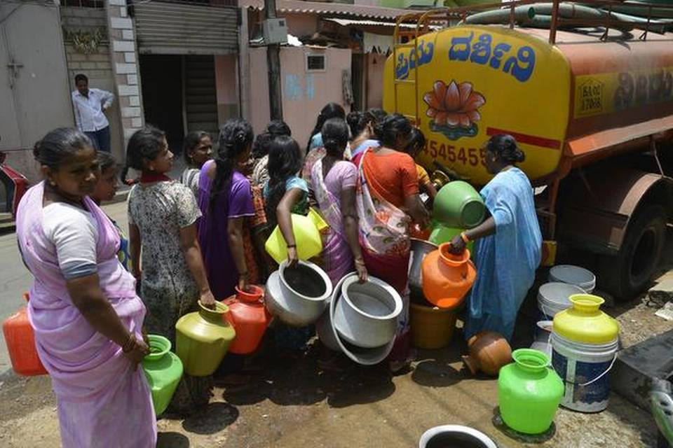 A image clicked during bengaluru water crisis, showcasing people filling water from the tankers.