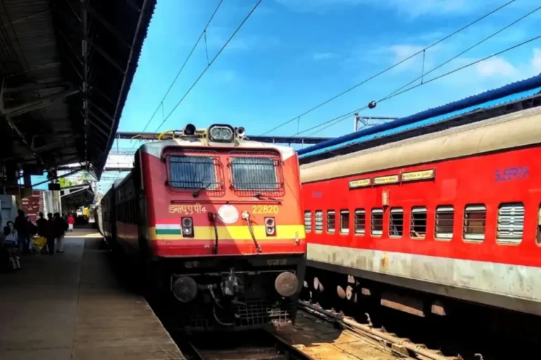 “An Indian Railways red express train stationed at a busy railway platform under bright blue sky — representing Puja Special Trains 2025. The image should convey the festive travel rush during Diwali and Chhath Puja season. Include passengers waiting on the platform, visible sleeper coaches, and the locomotive with Indian tricolour stripes on its front. Lighting should be natural daylight with vibrant colours highlighting the train and festive atmosphere. Ideal for a news feature on Indian Railways' special trains from Gorakhpur to Mumbai, Delhi, and Kolkata.”